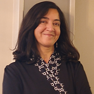 Dr. Hina Kazmi wearing a black blazer while standing and smiling.