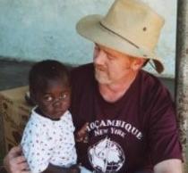 PhD Graduate Wayne Lavender with a small orphan on his lap